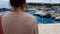 Young woman looking at yachts in Mediterranean Sea port, dreaming of rich life