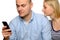 Young woman looks at her husband\'s phone.