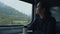 Young woman looks at the mountain landscape through the train window. Solo traveler, vacation concept