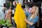 A young woman looks at yellow fabric in her sewing studio.