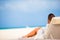 Young woman on lounger with mobile phone at the beach