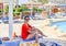 Young woman on a lounger with a sun umbrella by the pool at a resort.