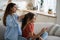 Young woman loving caring mother getting schoolkid ready for school in morning at home