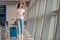 Young woman with luggage in international airport. Airline passenger in an airport lounge waiting for flight aircraft