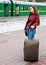 Young woman with luggage is waiting a train