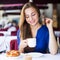 Young woman is lunching with croissant and coffee