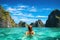 Young woman in luxury swimsuit relaxing in tropical lagoon, Ha Long bay, Vietnam, Young woman swimming in clear sea water in