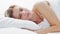 Young woman lying in the bed. Beautiful blond sleeping girl. Morning in the bedroom. Health and rest concept.