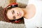 Young woman lying on the carpet and listenig a music in headphones