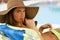 Young woman lying on deckchair by swimming-pool