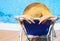 Young woman lying on deckchair by swimming pool