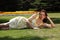 young woman lying on grass in summer sunshine