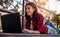 Young woman lying on step using laptop. College student is studying with laptop