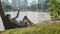 Young woman lying under palm tree using mobile phone in a park