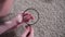 Young woman magnifying glass finds and examines animal hair on the carpet close up