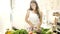 Young woman maintaining healthy lifestyle making fresh vegetable salad at kitchen