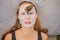 Young woman makes a face mask with snail mucus. Snail crawling on a face mask