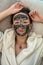 young woman makes herself a black clay regenerating mask that smoothes wrinkles.