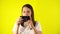 Young woman makes photo using vintage camera. Beautiful caucasian woman in t-shirt taking photo with old retro film