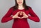 Young woman making her hands in heart shape. Heart health insurance, social world heart day
