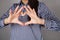 Young woman making her hands in heart shape. Heart health insurance, social world heart day