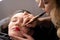 Young woman making lips tatouage in a dressing makeup room. Lips tatouage process .Woman making lips blushing. Make-up artist in