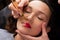 Young woman making lips tatouage in a dressing makeup room. Lips tatouage process .Woman making lips blushing. Make-up artist in