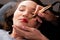 Young woman making lips tatouage in a dressing makeup room. Lips tatouage process .Woman making lips blushing. Make-up artist in