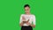 Young woman making notes while walking on a Green Screen, Chroma Key.