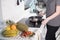 Young woman making pancakes on the kitchen. Fresh fruits on the table