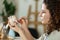 Young woman making pottery indoors at creative studio craftsperson concept sitting at table using modeling tool creating