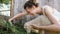 Young woman making selfie on smartphone with white sheep on the farm, lamb chewing grass