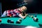 Young woman making shot in billiard