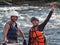 Young woman and man dressed in life jackets and helmets are close by and smile