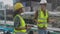 Young woman and man engineer walking and examining pipeline and looking digital tablet in the factory.