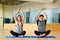 Young woman and man practicing yoga indoors