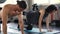 Young woman and man practicing yoga with Moon Bird Pose Yoga or Chakorasana on the gym floor. Two people couple working