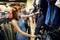 Young woman and man wearing protective face masks in a clothing store choosing new clothes in the sale department