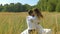 A young woman and a man in white suits flee to meet each other and embrace. On a sunny day, in a field with wheat.