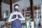 young woman manager wearing apron and face mask florist standing pose greeting