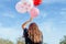 Young woman with many balloons walking