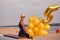 Young woman with many golden balloons.