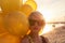 Young woman with many golden balloons.