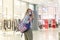 Young woman in a mask at the mall. Blonde girl with a backpack in the season of sales