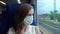 Young Woman in Mask in Moving Train looking in Window