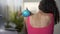 Young woman massaging shoulders with ball, soothing muscles after working out