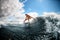 Young woman masterfully rides on surfboard along the wave and touches the water