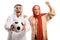 Young woman and mature arab man in ethnic clothes holding a football and cheering