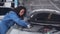 Young woman is mechanic repairing engine of car in the garage, auto service, worker fix and adjusting part of automobile.