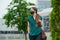 A young woman in a medical face mask walks keeping social distance in downtown